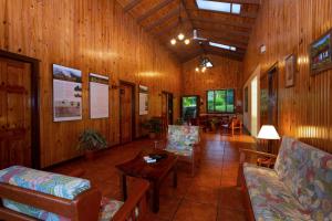a living room with wooden walls and chairs and a table at Arenal Observatory Lodge & Trails in Fortuna