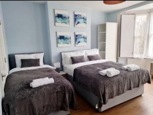 a bedroom with two beds with towels on them at Stylish 2 Bedroom Apartment Sleeps 5 - 3 mins walk to Mile End Station in London