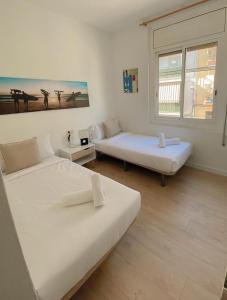 una stanza con due letti e una finestra di Sitges Best Holidays Apartment a Sitges