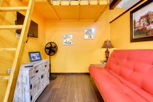 a living room with a red couch and a ladder at Bright Cabin with Fire Pit - 2 Mi to Holden Beach! in Supply