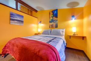 a bedroom with yellow walls and a bed with two lamps at Bright Cabin with Fire Pit - 2 Mi to Holden Beach! in Supply