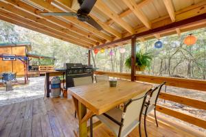 a wooden dining room with a table and a stove at Bright Cabin with Fire Pit - 2 Mi to Holden Beach! in Supply