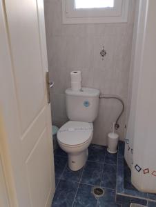 a small bathroom with a toilet and a window at Calypso Two Bedroom Apartment in Kandia