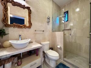 y baño con aseo, lavabo y espejo. en Loft El Anhelo en Val'Quirico, en Santeagueda