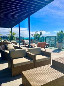 a patio with chairs and tables and a view of the ocean at LIV 404 - Maceió - Ponta Verde in Maceió