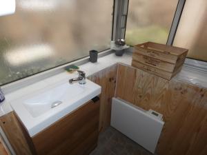 ein Bad mit einem Waschbecken und einem Fenster in der Unterkunft chez Flo in Thann