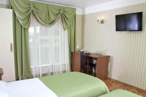 a bedroom with a bed and a desk and a television at Moskovskaya Zastava Hotel in Kostroma