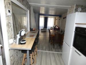 eine Küche und ein Wohnzimmer mit einem Tisch und einem Kühlschrank in der Unterkunft chez Flo in Thann