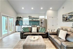 a living room with two leather couches and a kitchen at La Puerta Rosada - Gorgeous home w Private Pool in Port Aransas +31 photos