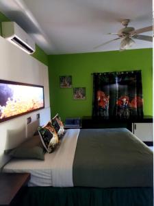 um quarto com uma cama grande e paredes verdes em Cas Bed and Breakfast em Corral Spring
