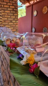 a table with some food and flowers on it at Pousada Brasil - São Miguel do Gostoso in São Miguel do Gostoso
