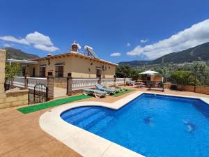 a villa with a swimming pool and a house at Los Olivos in Málaga