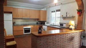 a kitchen with wooden cabinets and a brick wall at Los Olivos in Málaga