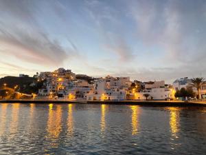 een groep witte gebouwen aan de oever van een waterlichaam bij Casa Aloe C. Las Playitas. in Las Playitas
