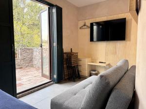 een woonkamer met een bank en een televisie bij Loft Venezia III ValQuirico 2Pax in Santeagueda
