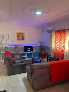 uma sala de estar com dois sofás e uma televisão em RÉSIDENCE VGP LOGPOM em Douala