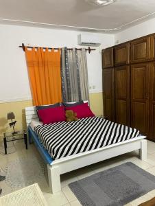 uma cama num quarto com uma cortina laranja em RÉSIDENCE VGP LOGPOM em Douala