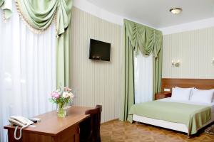 a hotel room with a bed and a desk with a phone at Moskovskaya Zastava Hotel in Kostroma