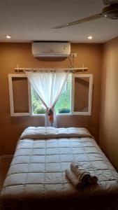 1 dormitorio con 1 cama grande y ventana en La Morada Hostal en Cafayate