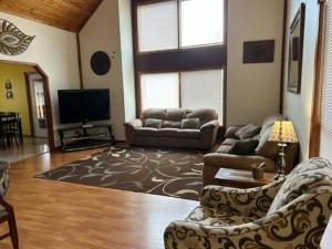 a living room with couches and a flat screen tv at Luxury Cabin #21 With Hot Tub and Jacuzzi on Patoka Lake in Southern Indiana in Paoli