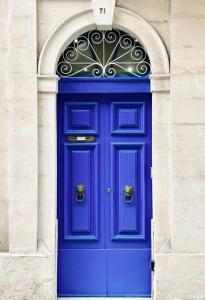 a blue door in a building with an arch at San Francisco Studios Valletta in Il-Furjana