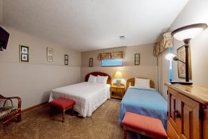 a bedroom with two beds and two chairs at Minutes from Everything in Branson