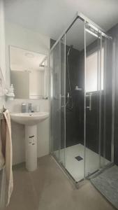 W łazience znajduje się szklana kabina prysznicowa i umywalka. w obiekcie Apartamento moderno y coqueto en playa San Juan w Alicante
