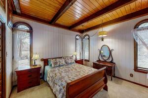 een slaapkamer met een bed en een houten plafond bij The Castle on Cedar Creek Lake in Tool