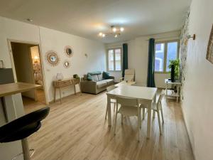 uma sala de estar com uma mesa e um sofá em Chic'appart em Cavaillon