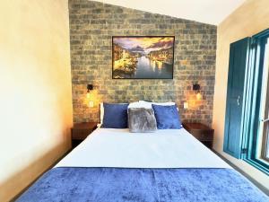 - une chambre avec un grand lit et des oreillers bleus dans l'établissement Loft Venezia en Val'Quirico 3Rec, Terraza privada, à Santeagueda