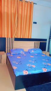 a bed with a blue comforter with flowers on it at Timba Miché04 in Cotonou