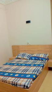a bed with a blue and white comforter on it at Timba Miché04 in Cotonou