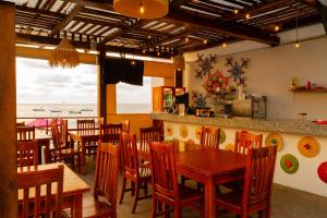 a restaurant with wooden tables and chairs and the ocean at Santa Martha Bungalows in Los Ayala
