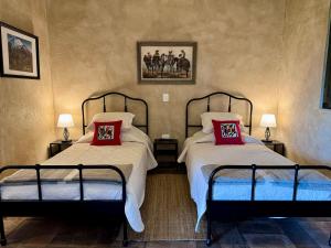 una camera con 2 letti con cuscini rossi di Loft El Tapatío en Val'Quirico a Santeagueda