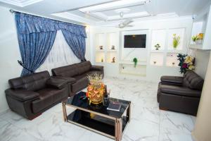 a living room with two leather couches and a table at Royal N Hotel in Accra