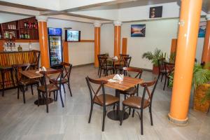 a dining room with wooden tables and chairs at Royal N Hotel in Accra