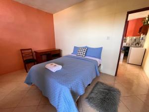 a bedroom with a bed with a blue blanket at Casa de Huéspedes Paola in Puerto Baquerizo Moreno