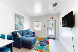 a living room with a blue couch and a flat screen tv at Hallandale Haven in Hallandale Beach