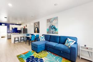 a living room with a blue couch and a kitchen at Hallandale Haven in Hallandale Beach