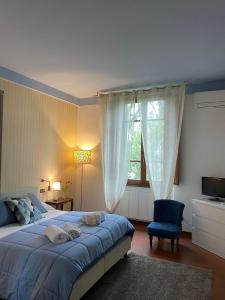 1 dormitorio con 1 cama azul y 1 silla azul en Villa Lia - Apartment in Villa with private garden and Pool en Florence