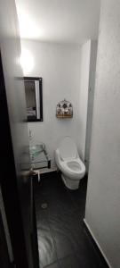 a bathroom with a white toilet and a sink at Hotel Paradise Lleras in Medellín