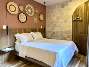 ein Schlafzimmer mit einem Bett und ein paar Platten an der Wand in der Unterkunft Val'Quirico Lucca 84 Loft Toscano in Santeagueda