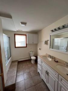 y baño con aseo, 2 lavabos y espejo. en Arcadia Cabin #25 at Patoka 4 Seasons Resort, en Salem
