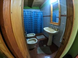 a bathroom with two toilets and a sink at CABAÑA ABRA ANCHA in Aluminé