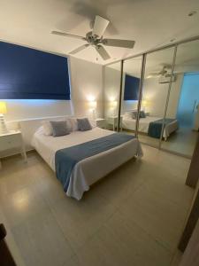 Schlafzimmer mit einem Bett und einem Deckenventilator in der Unterkunft Apartamento frente al Mar Cartagena in Cartagena de Indias
