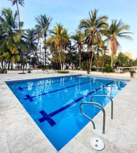 ein großer Pool mit Palmen im Hintergrund in der Unterkunft Apartamento frente al Mar Cartagena in Cartagena de Indias