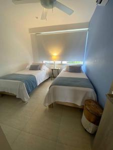 1 Schlafzimmer mit 2 Betten und einem Deckenventilator in der Unterkunft Apartamento frente al Mar Cartagena in Cartagena de Indias