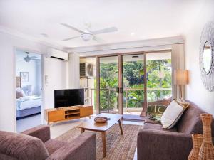 uma sala de estar com um sofá e uma televisão em Maimi renovated 2-bedroom apartment em Gold Coast