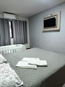 a bedroom with a bed with two towels on it at NC Hotel in Bragança Paulista