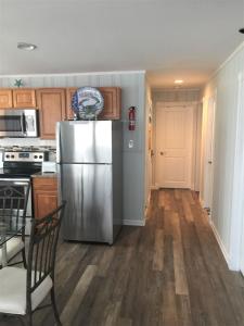a kitchen with a stainless steel refrigerator and wooden floors at 6B Best Location, 4 bedrm, 2 bathrm Beach Block in Seaside Heights